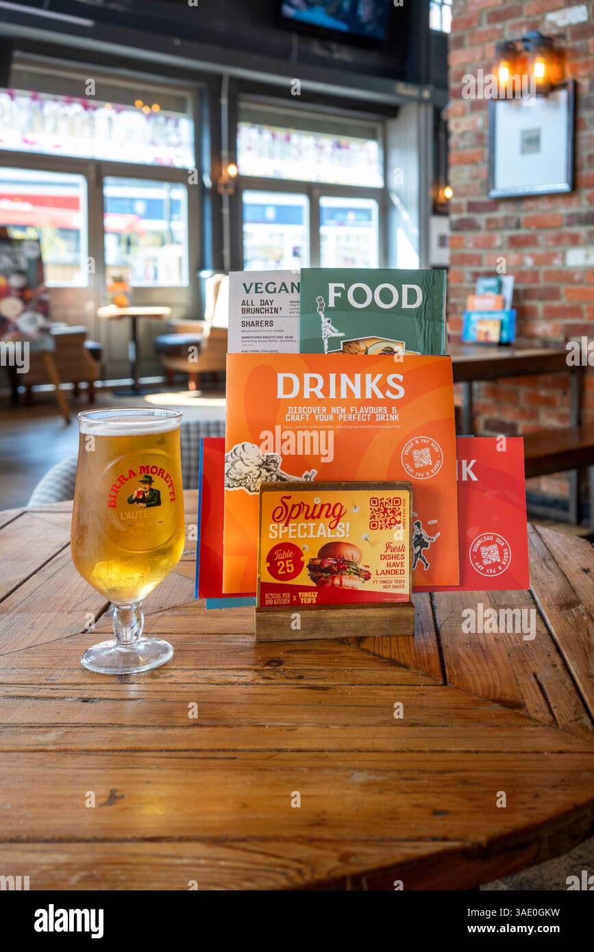 Menu di bevande e cibo da pub con un bicchiere di birra su un tavolo di legno Foto Stock