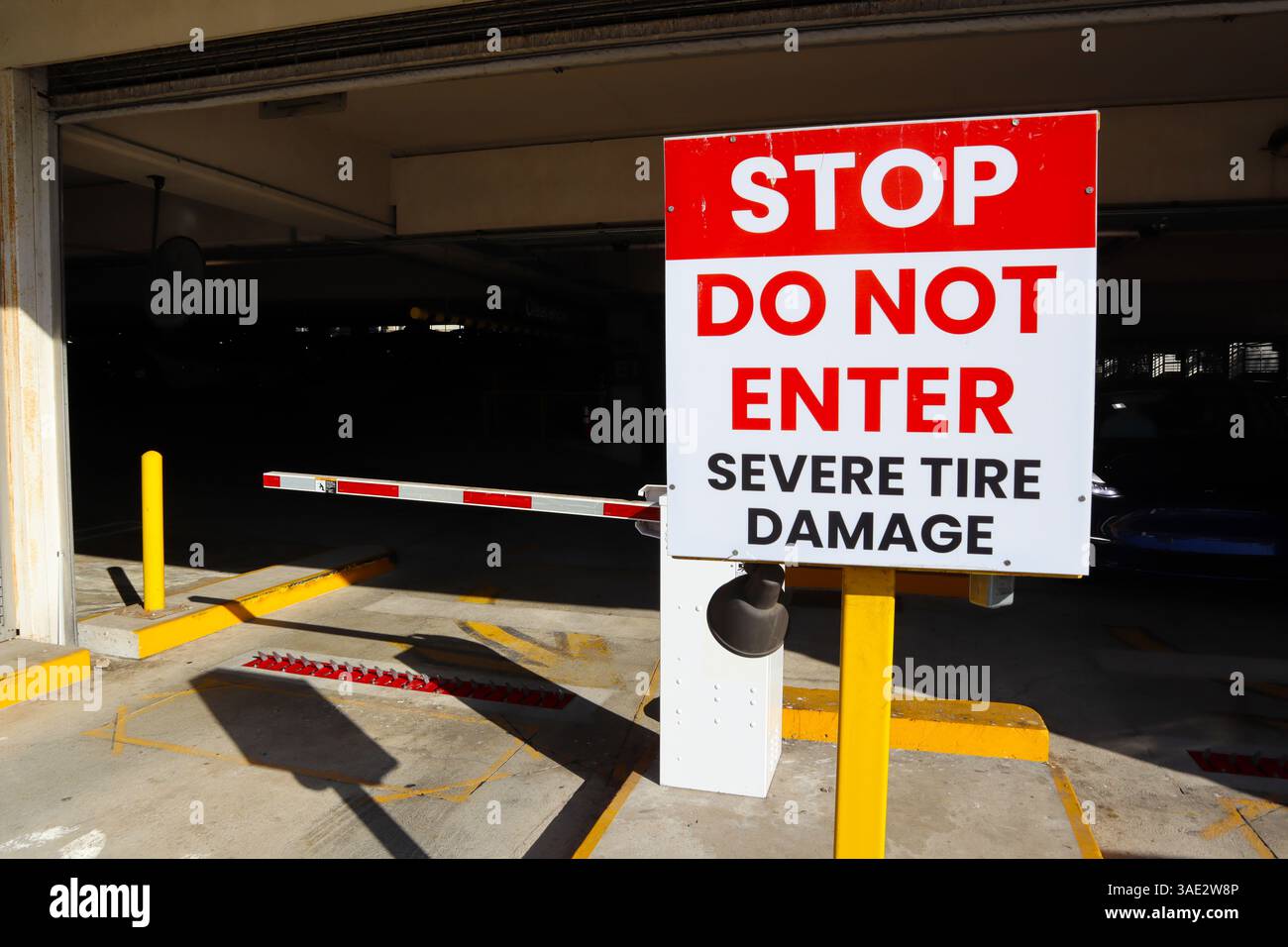 Uscita del garage pubblico con il cartello "STOP, non entrare, gravi danni agli pneumatici" Foto Stock