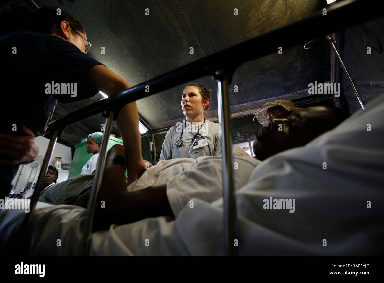 10 gennaio 2012 - Milot, Haiti - GENEVIEVE PETRAGLIA, RN, estrema sinistra, e BROOKE SULLIVAN, centro, trattare un paziente nella tenda che funge da pronto soccorso per l'ospedale Sacre Coeur. (Immagine di credito: © Peggy Peattie/The San Diego Union-Tribune/zReportage.com/ZUMA) Foto Stock