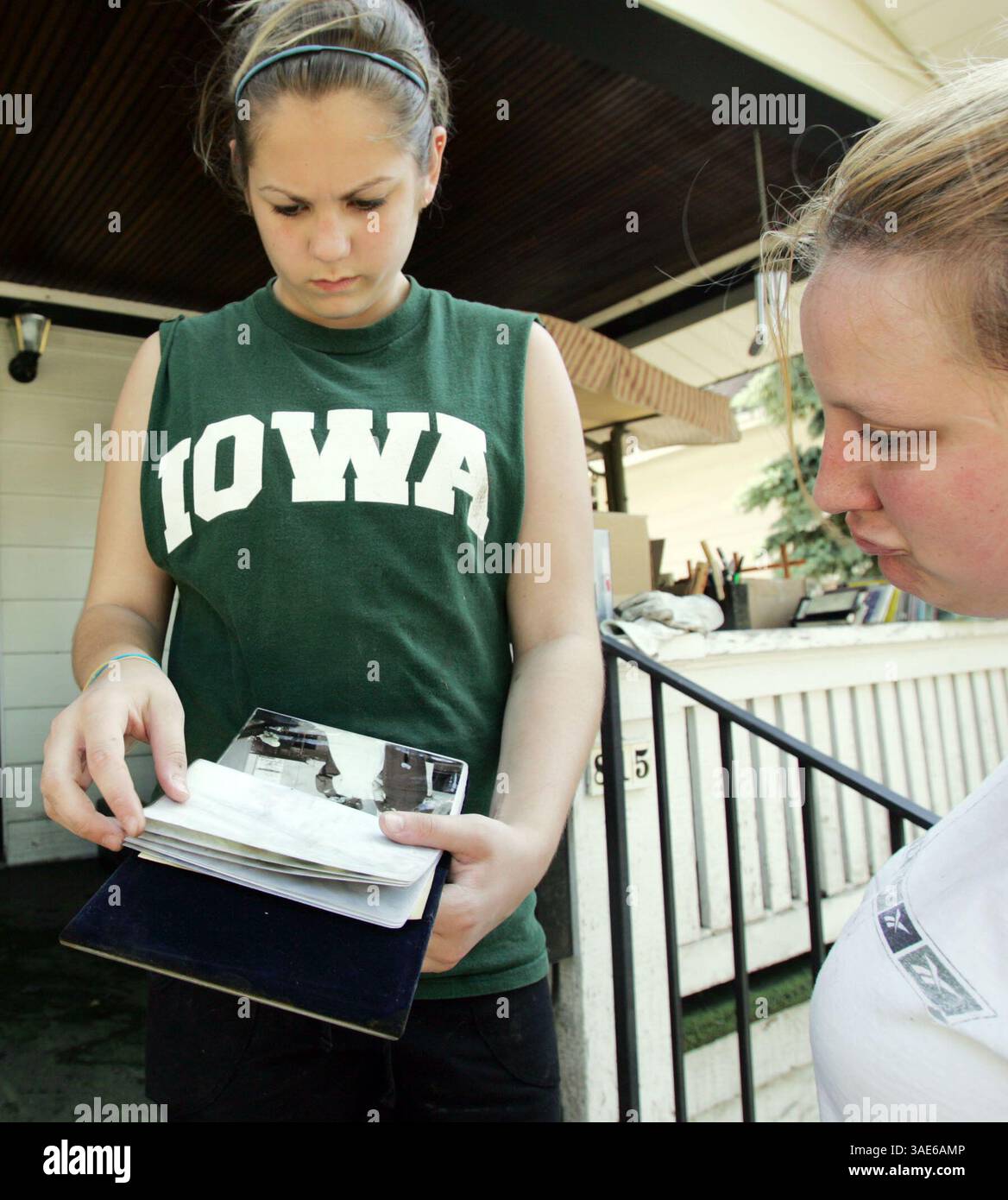 18 giugno 2008 - Cedar Rapids, Iowa, Stati Uniti - Shelby Holvenstot, 13 anni, a sinistra, mostra l'album di foto nuziali danneggiato dei suoi genitori al collega di suo padre Jen Schenk di Cedar Rapids mentre puliscono il tempo degli Holvenstot Check home a Northwest Cedar Rapids (immagine di credito: Cedar Rapids Gazette/ZUMAPRESS.com) Foto Stock