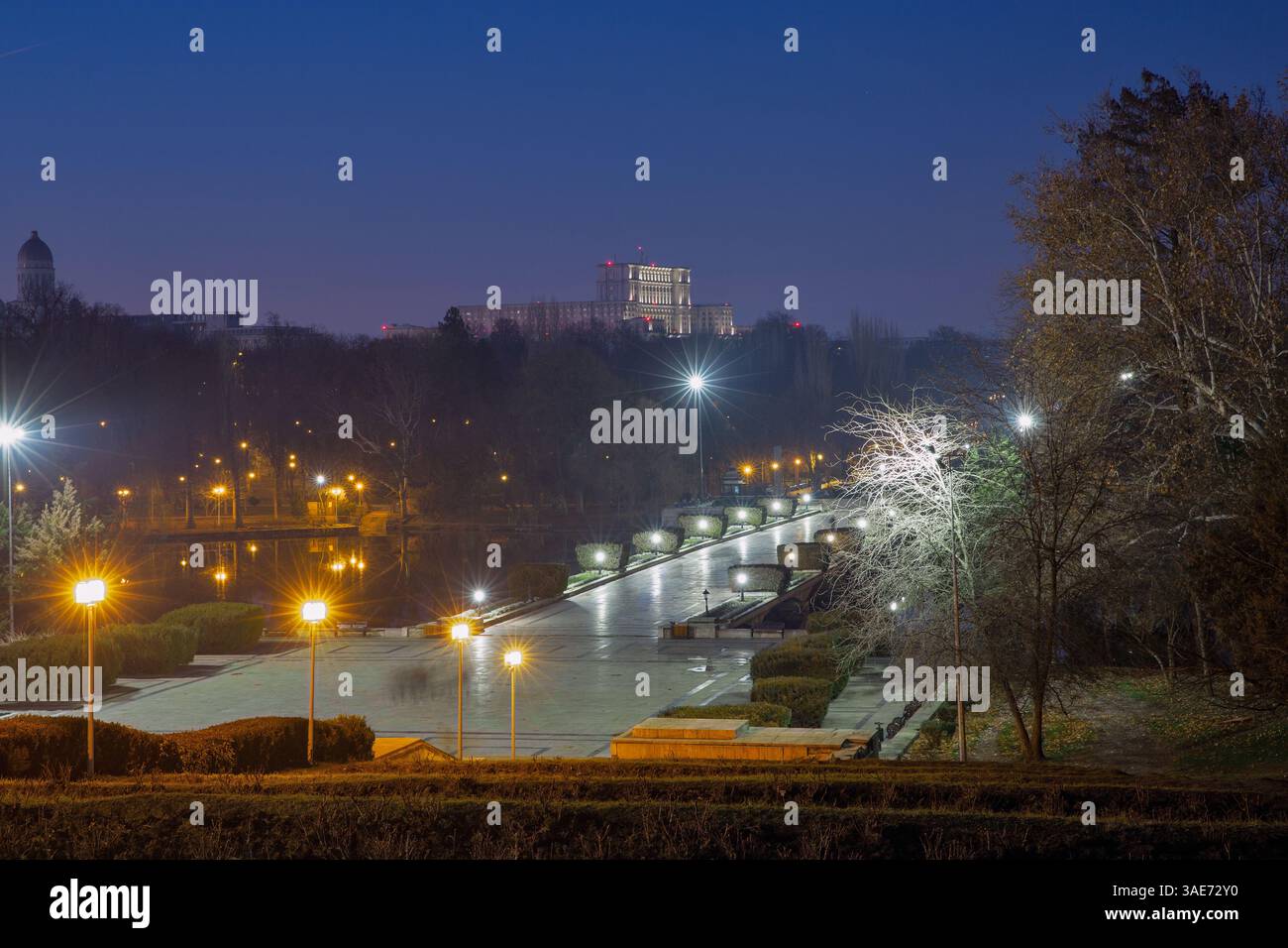 Vista dal National Heroes Memorial sul Carol Park di notte con il lago e il Palazzo del Parlamento sullo sfondo. Bucarest, Romania. Foto Stock
