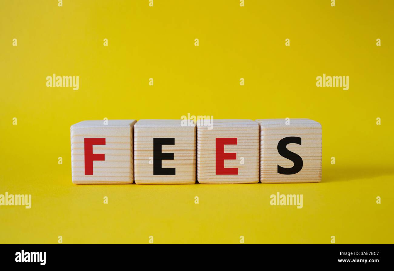 Simbolo delle tariffe. Costo della parola concettuale sui cubi di legno. Bellissimo sfondo giallo. Business e tariffe. Copia spazio. Foto Stock
