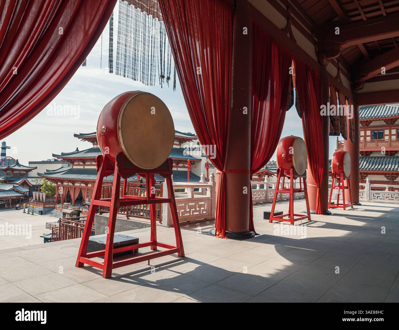 I tamburi si allineano in un ambiente architettonico tradizionale durante un pomeriggio di sole Foto Stock