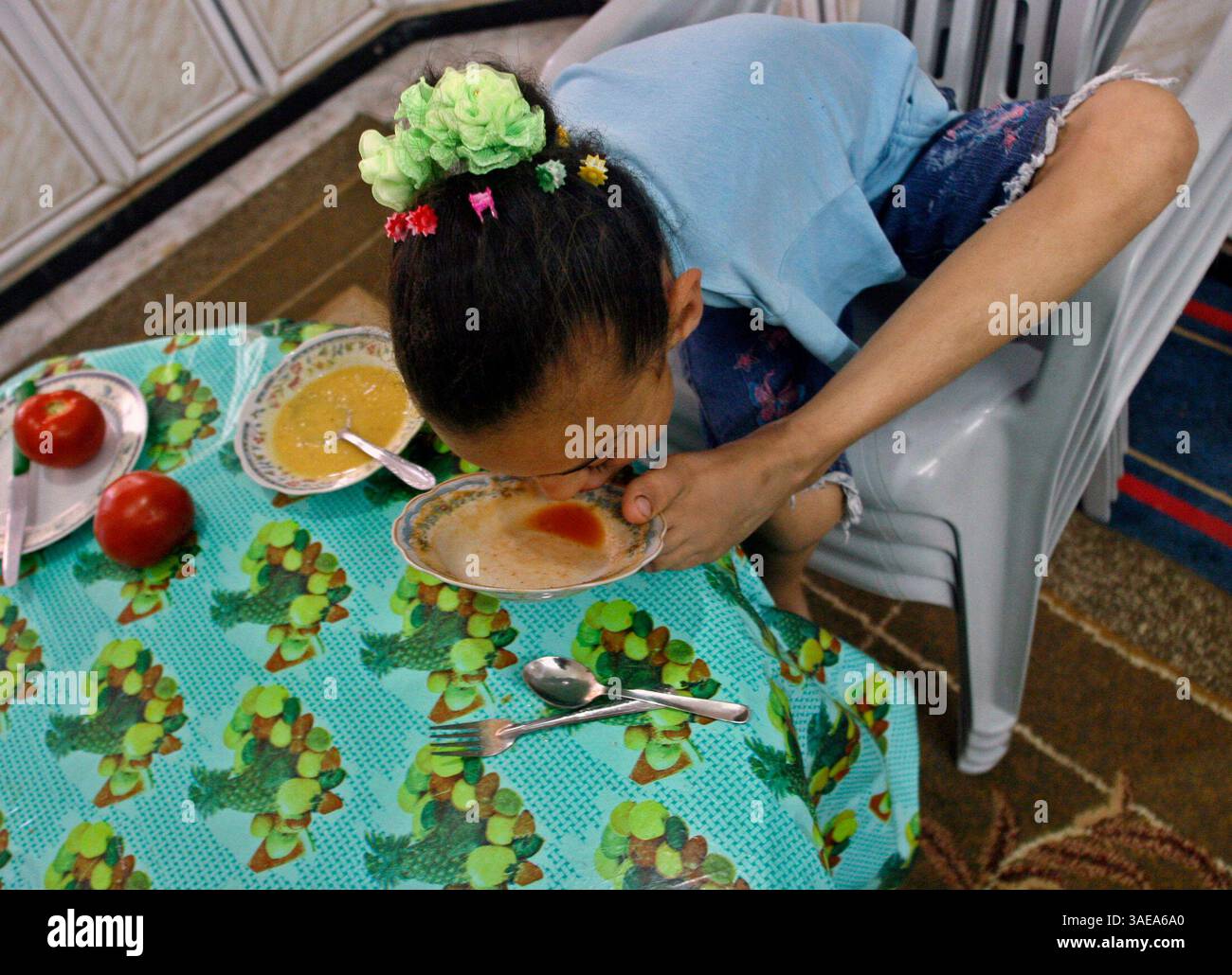 09 giugno 2008 - Gaza City, Striscia di Gaza - AYA MASOUAD di 8 anni è nata senza braccia e usa dita dei piedi e dei piedi nella sua vita quotidiana. Aya ama la sua vita e ringrazia Dio mentre cerca di vivere la sua vita come la maggior parte delle persone. NELLA FOTO: Aya gusta ogni goccia della sua cena di spaghetti a casa (Credit Image: PROPA Images/ZUMAPRESS.com) Foto Stock