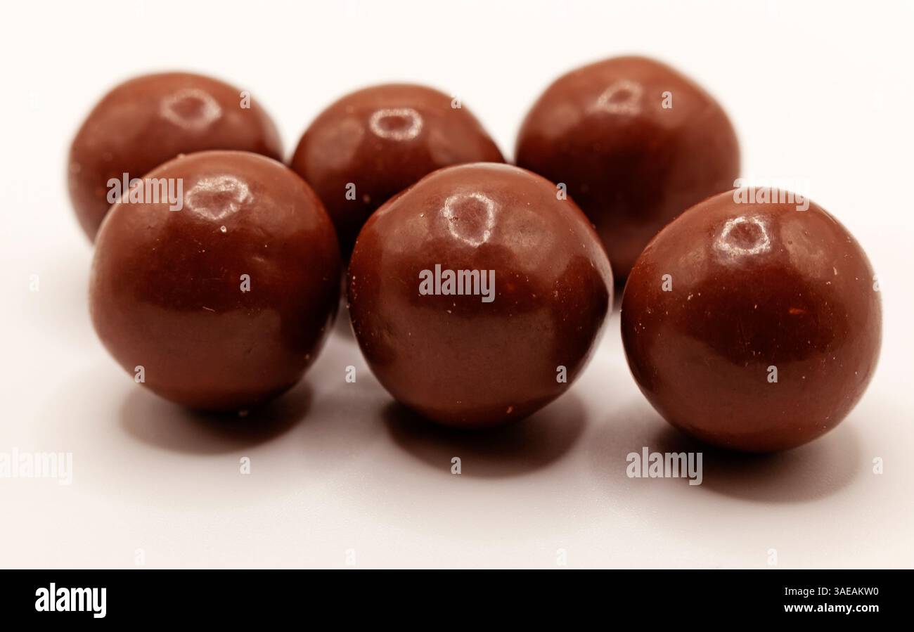 Questa immagine mostra una collezione di palline di cioccolato fondente lucide, che suggeriscono una caramella decadente con un tocco di rum. Foto Stock