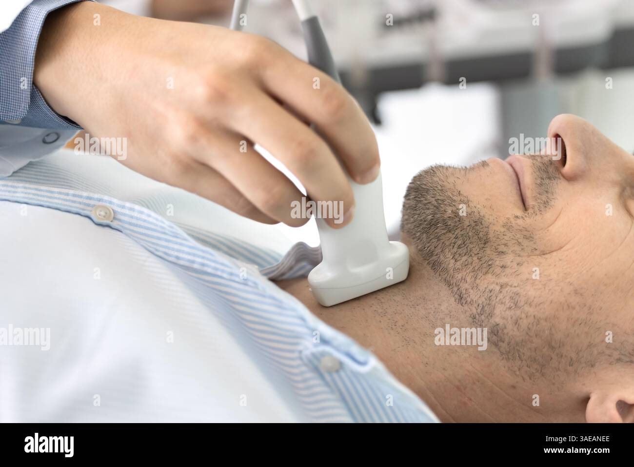 Primo piano di un maschio sottoposto a esame ecografico della tiroide in clinica Foto Stock