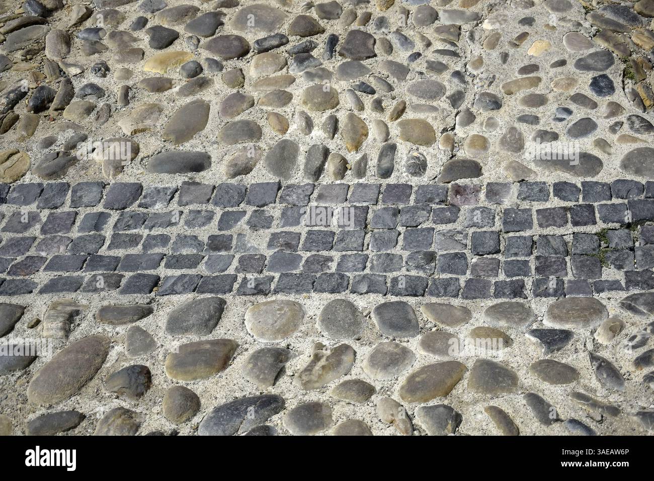 Strada acciottolata. Vecchia strada lastricata di pietre. Primo piano. Copia spazio. Messa a fuoco selettiva. Foto Stock