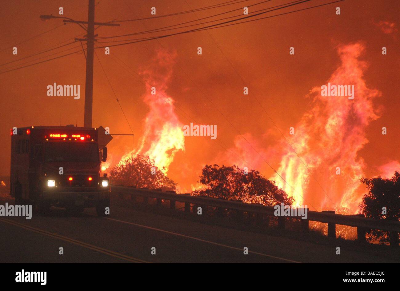 21 ottobre 2007 - Malibu, California, Stati Uniti - Un camion dell'equipaggio dei vigili del fuoco della contea di Los Angeles passa vicino alle fiamme lungo Malibu Canyon Road (immagine di credito: Mike Meadows/ZUMAPRESS.com) Foto Stock