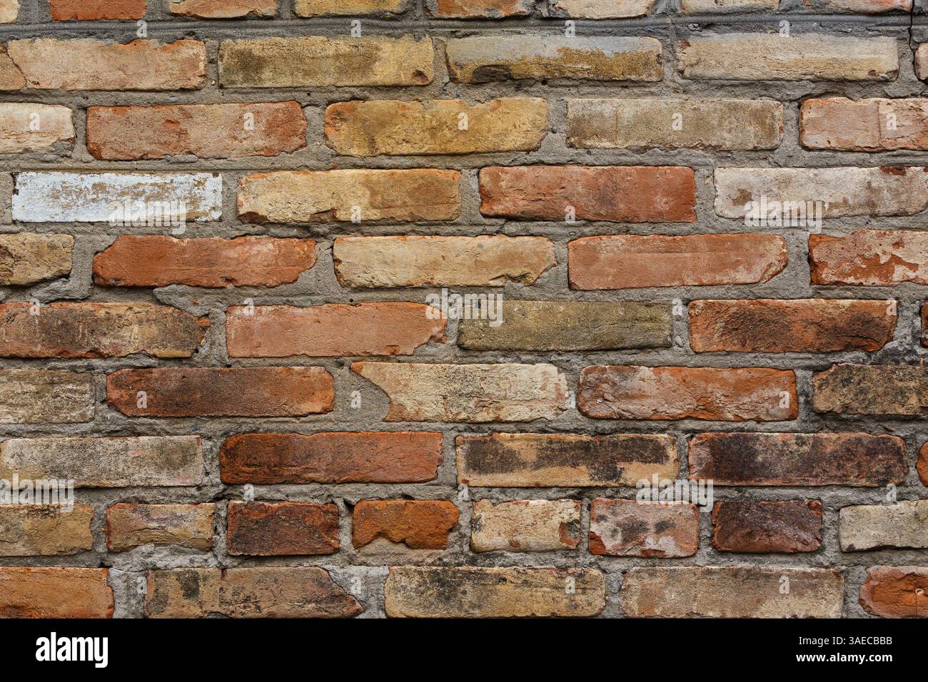 Vecchio muro di mattoni. Sfondo geometrico di mattoni multicolori. Mattoni. Foto Stock