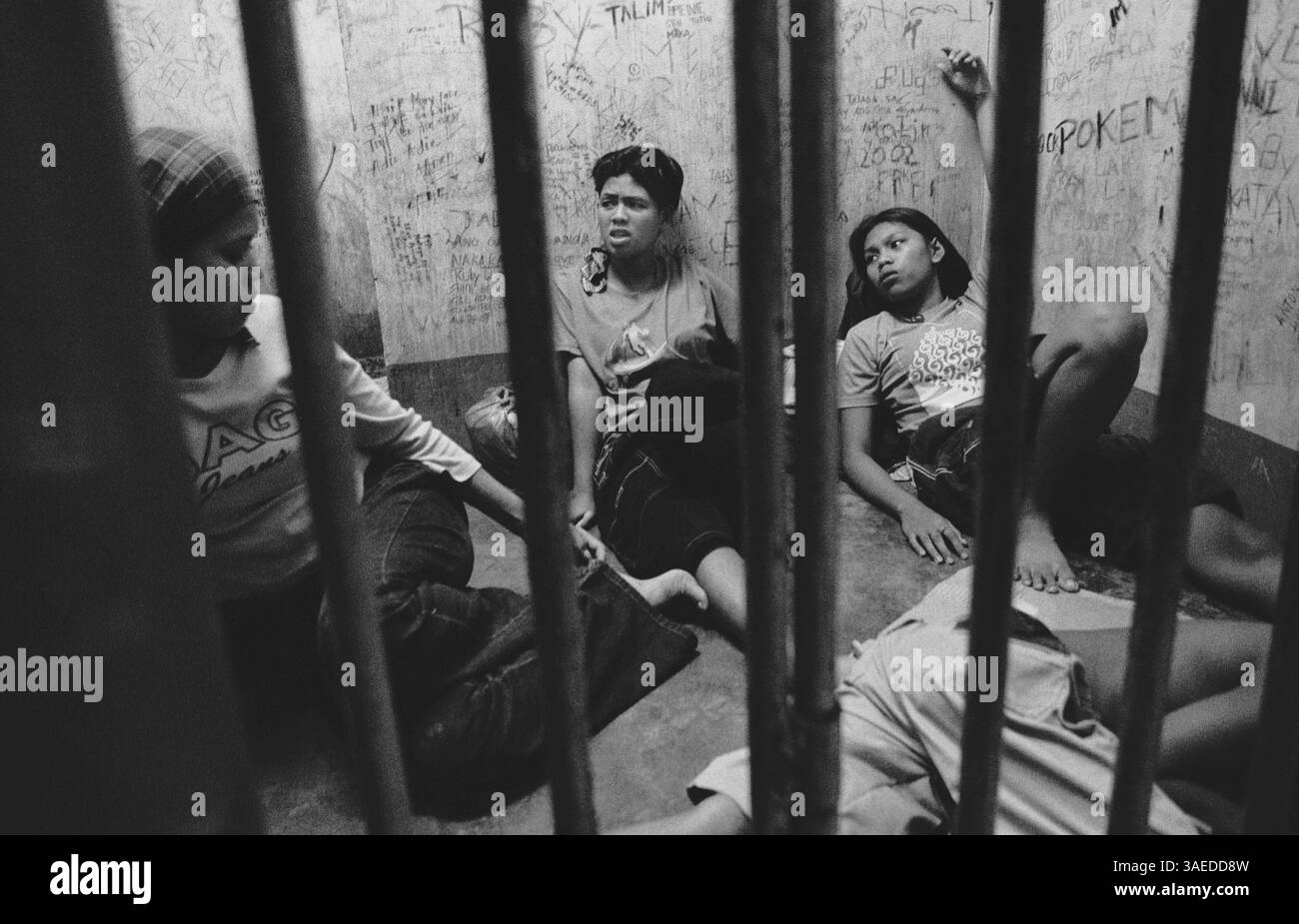 31 agosto 2006; Davao City, Filippine; la polizia di Santa Ana ha arrestato Diane, Left, Maricel, Center, e Ruby per possesso di colla Rugby e ha chiuso i tre membri della banda all'interno di una cella ristretta per due settimane senza accuse formali prima di trasferirli nella prigione di Maa City. Rispetto ai ragazzi, un minor numero di ragazze di strada di Davao, Filippine, vengono arrestate per piccoli reati come il furto o l'abuso di sostanze. Molti di loro, tuttavia, cercano compagnia e protezione nelle bande, che spesso espongono i loro membri alla violenza, alla droga e agli scontri con la polizia. E' chiaro che le strade di Davao Cit Foto Stock