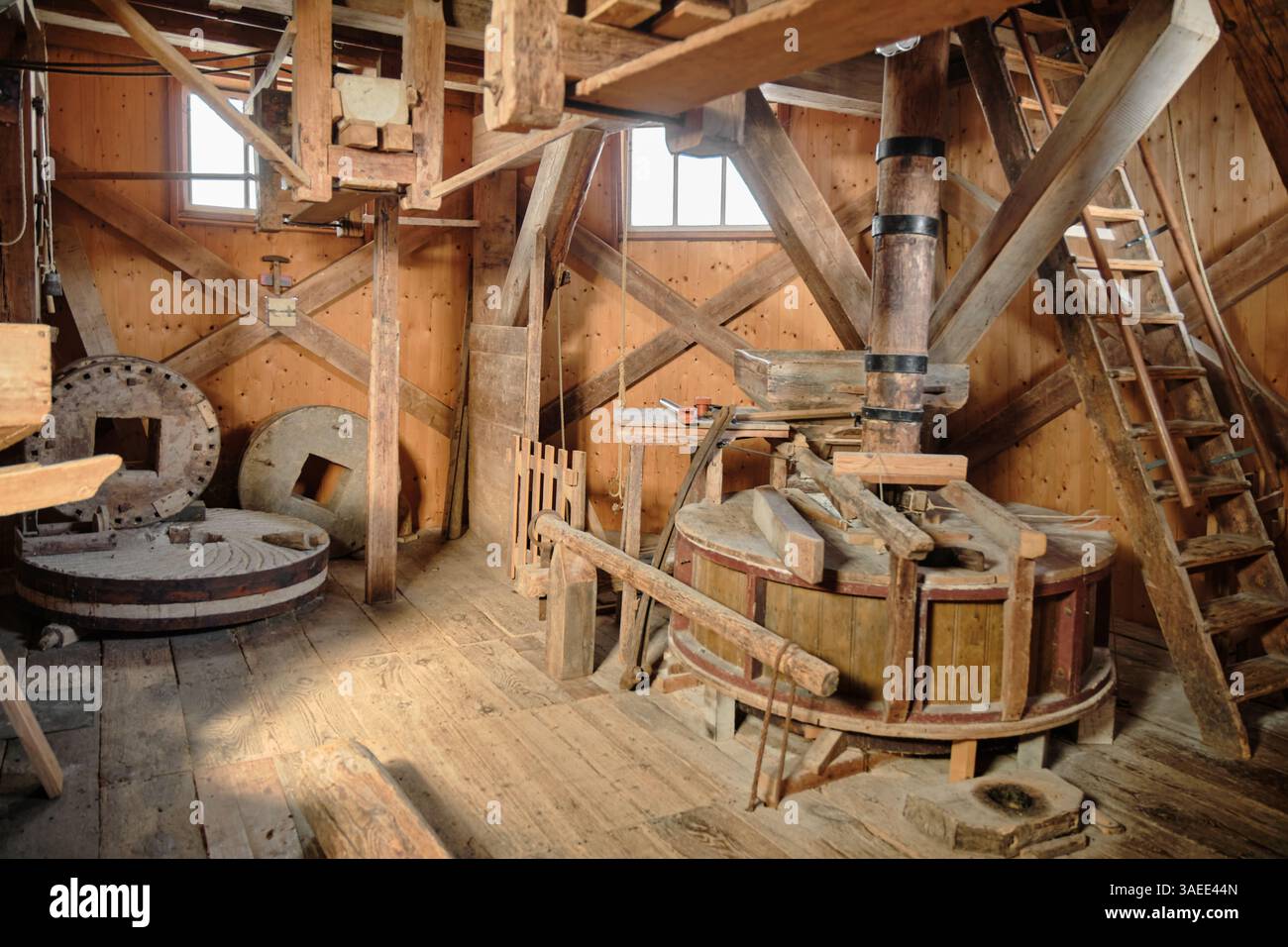 10 marzo 2025 - Spijk, Paesi Bassi: Secondo piano del mulino a vento Cerere con la pietra di legno e la pietra di macinazione fuori uso e l'attrezzatura nella parte posteriore. Foto Stock