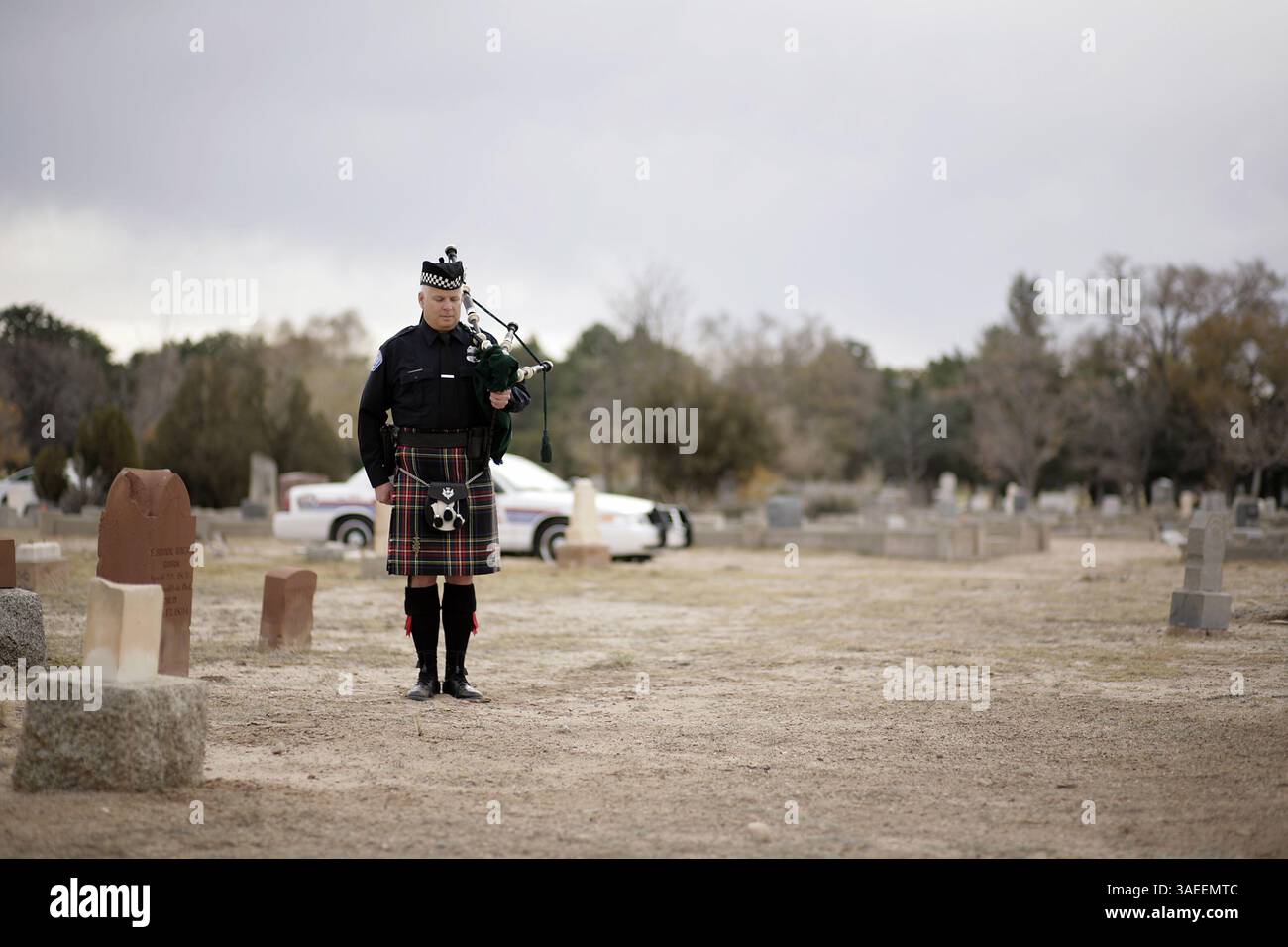 20 novembre 2011 - Albuquerque, NEW MEXICO, Stati Uniti - asec. L'ufficiale dell'APD Scott Mills (CQ) si ferma per suonare Amazing Grace sulle pipe della borsa durante un servizio di commemorazione della tomba per il vice maresciallo E.D. Henry, che è stato il primo ufficiale delle forze dell'ordine di Albuquerque ad essere ucciso durante il servizio, fotografato presso lo storico Fairview Cemetery lunedì 21 novembre 2011. Henry è morto il 20 novembre 1886. (Immagine di credito: © Pat Vasquez-Cunningham/Albuquerque Journal/ZUMAPRESS.com) Foto Stock