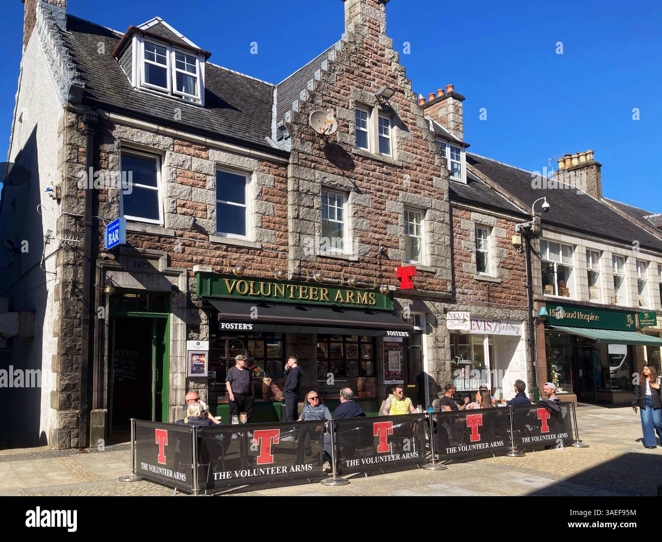Pub Voluntary Arms con tavoli all'aperto in una giornata di sole, Fort William High Street, Fort William Scotland - Immagine stock catturata con smartphone