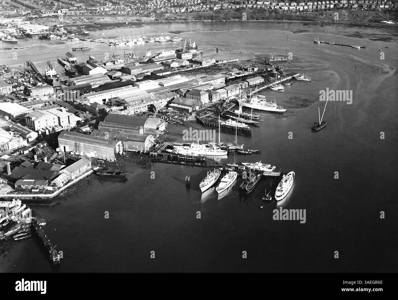 AJAXNETPHOTO. 1954-5 (CIRCA). NORTHAM, SOUTHAMPTON, INGHILTERRA. - IL FAMOSO CANTIERE NAVALE SUL FIUME ITCHEN - UNA VISTA AEREA DEL CAMPER E DEL CANTIERE NAVALE NORTHAM DI NICHOLSON SUL FIUME ITCHEN. LO YACHT CLASSE J ENDEAVOR 1 COSTRUITO DA C&N GOSPORT PER LA SFIDA DELLA COPPA AMERICA 1934 DI T.O.M.SOPWITH, È VISIBILE AL CENTRO A DESTRA, SOTTO IL GRANDE YACHT BIANCO. FOTO: VTCOLLECTION/AJAX RIF:MX340 252202 1. Foto Stock