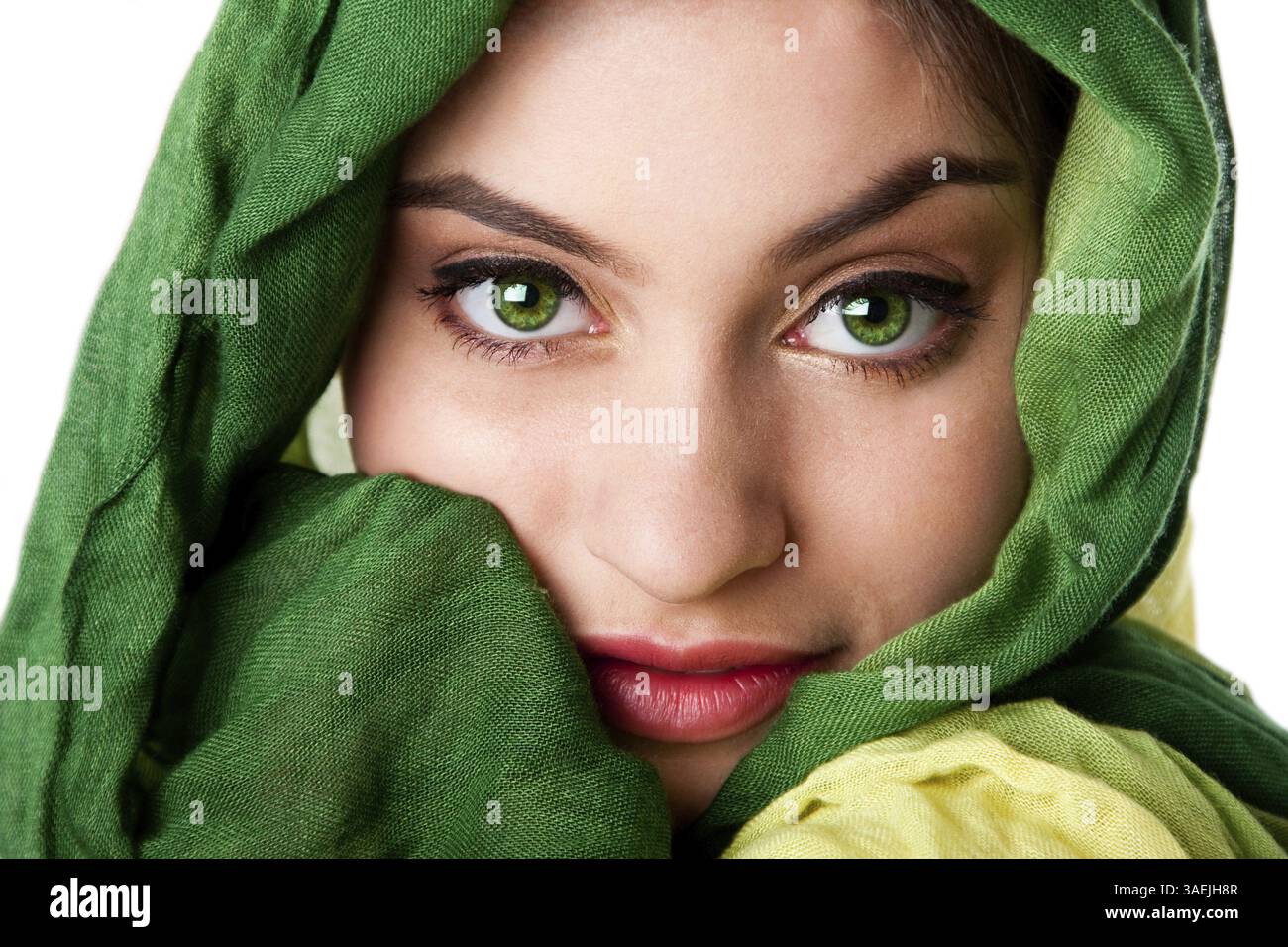 Ritratto di misteriosa bella ispanica caucasica Latina donna faccia verde con occhi penetranti e moda verde sciarpa avvolta attorno alla testa, isolare Foto Stock