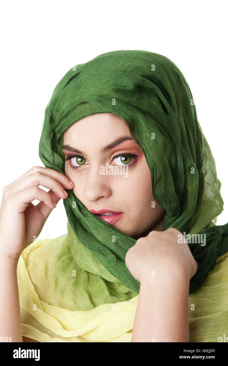 Ritratto di timido misteriosa bella ispanica caucasica Latina donna faccia verde con occhi penetranti e moda verde sciarpa avvolta attorno alla testa, iso Foto Stock