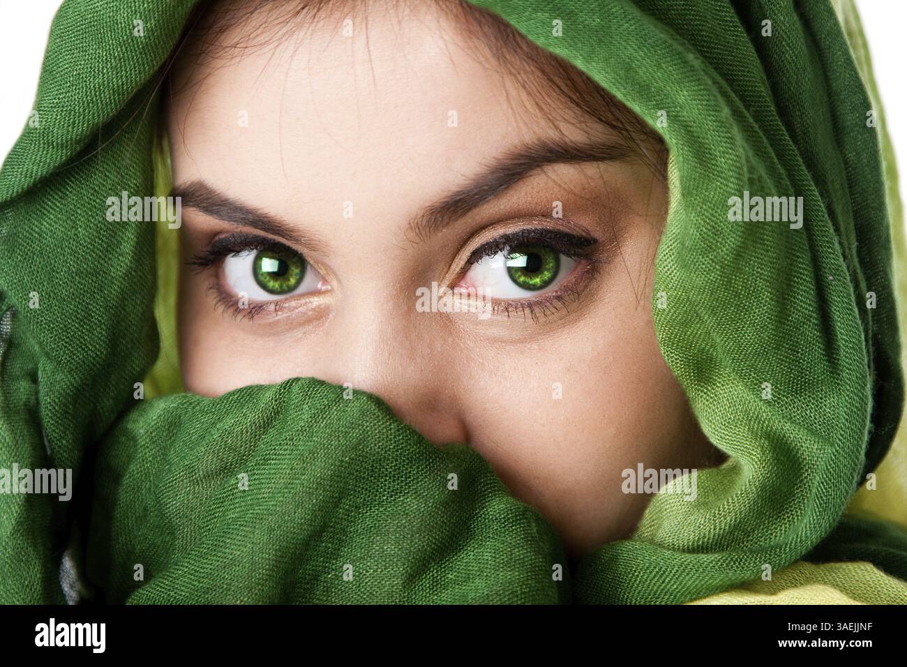 Ritratto di misteriosa bella ispanica caucasica Latina donna faccia verde con occhi penetranti e moda verde sciarpa avvolta attorno alla testa e mout Foto Stock