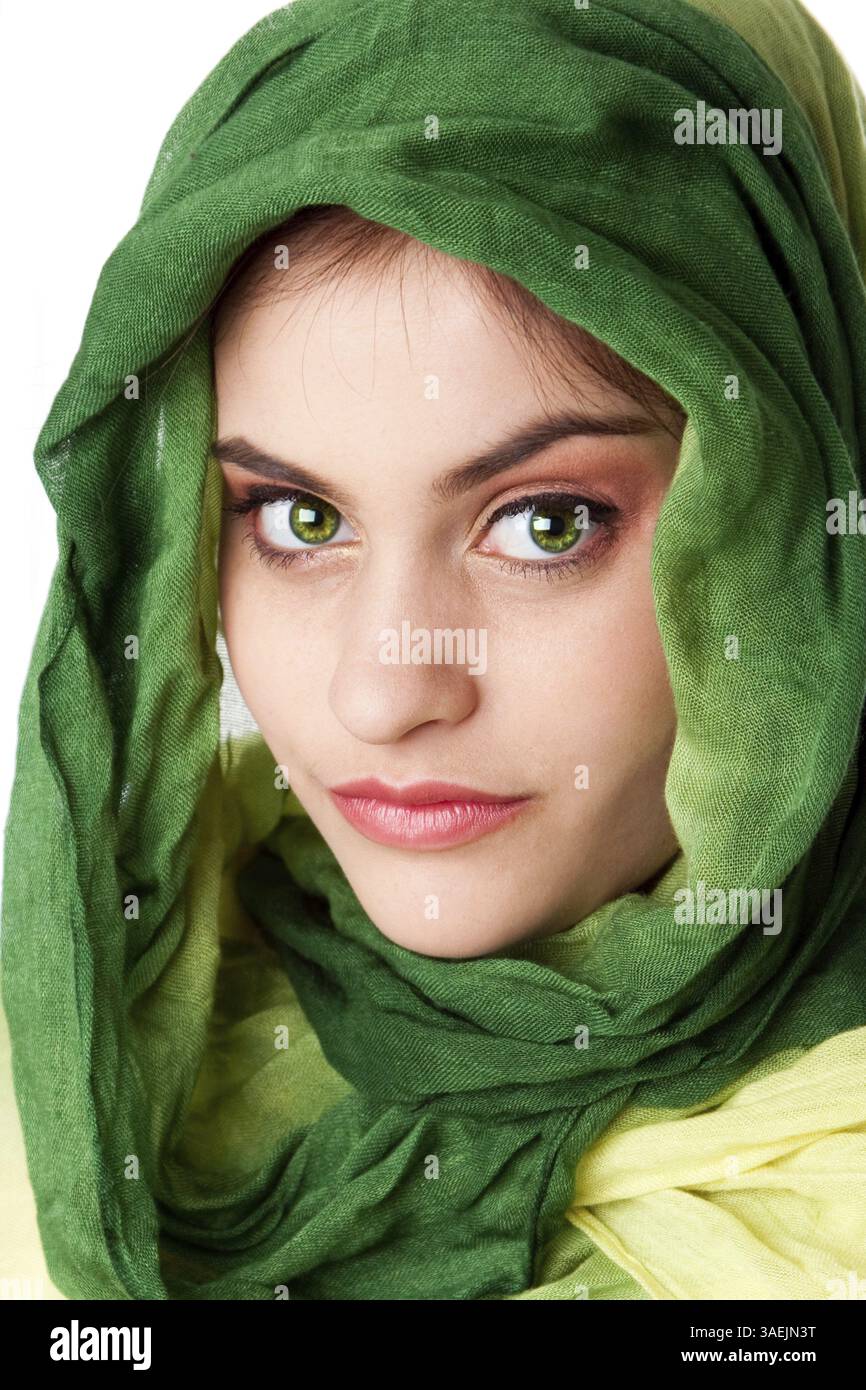 Ritratto di misteriosa bella ispanica caucasica Latina donna faccia verde con occhi penetranti e moda verde sciarpa avvolta attorno alla testa, isolare Foto Stock