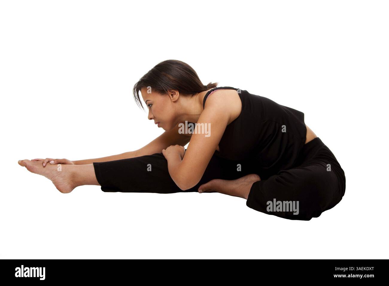 Bella donna attraente esercizio di stretching prima del suo allenamento di yoga, vestito di nero, isolato, New York, USA, nord America Foto Stock
