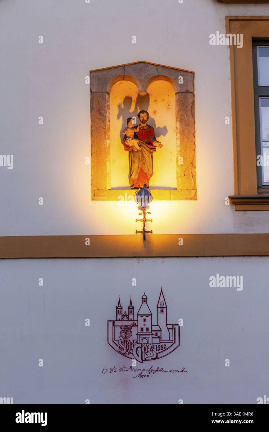Gruppo scultoreo in una nicchia, santo che tiene il bambino Gesù, raffigurazione del decreto di dissoluzione dell'Abbazia di Goess, ex convento della suora benedettina Foto Stock
