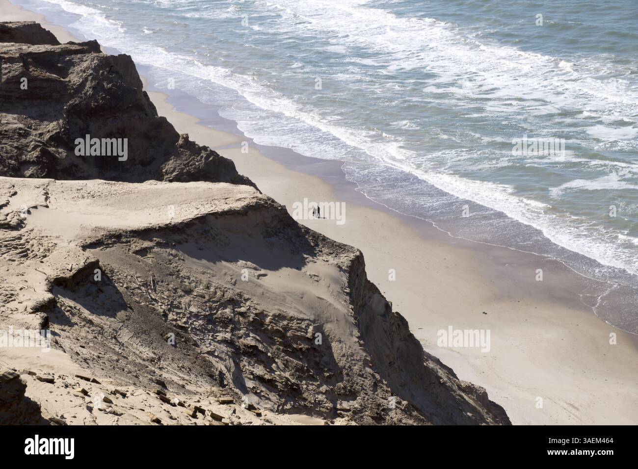 Foto della coppia che cammina sulla spiaggia di Rujerg si nuda contro le dune di sabbia e naviga in orizzontale in danimarca Foto Stock