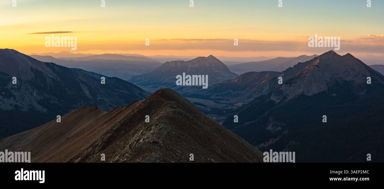 Monte Crested Butte (12.162') e montagna Gotica (12.631') nella catena degli alci del Colorado che si innalzano sopra la Valle Gotica durante una drammatica alba autunnale. Foto Stock