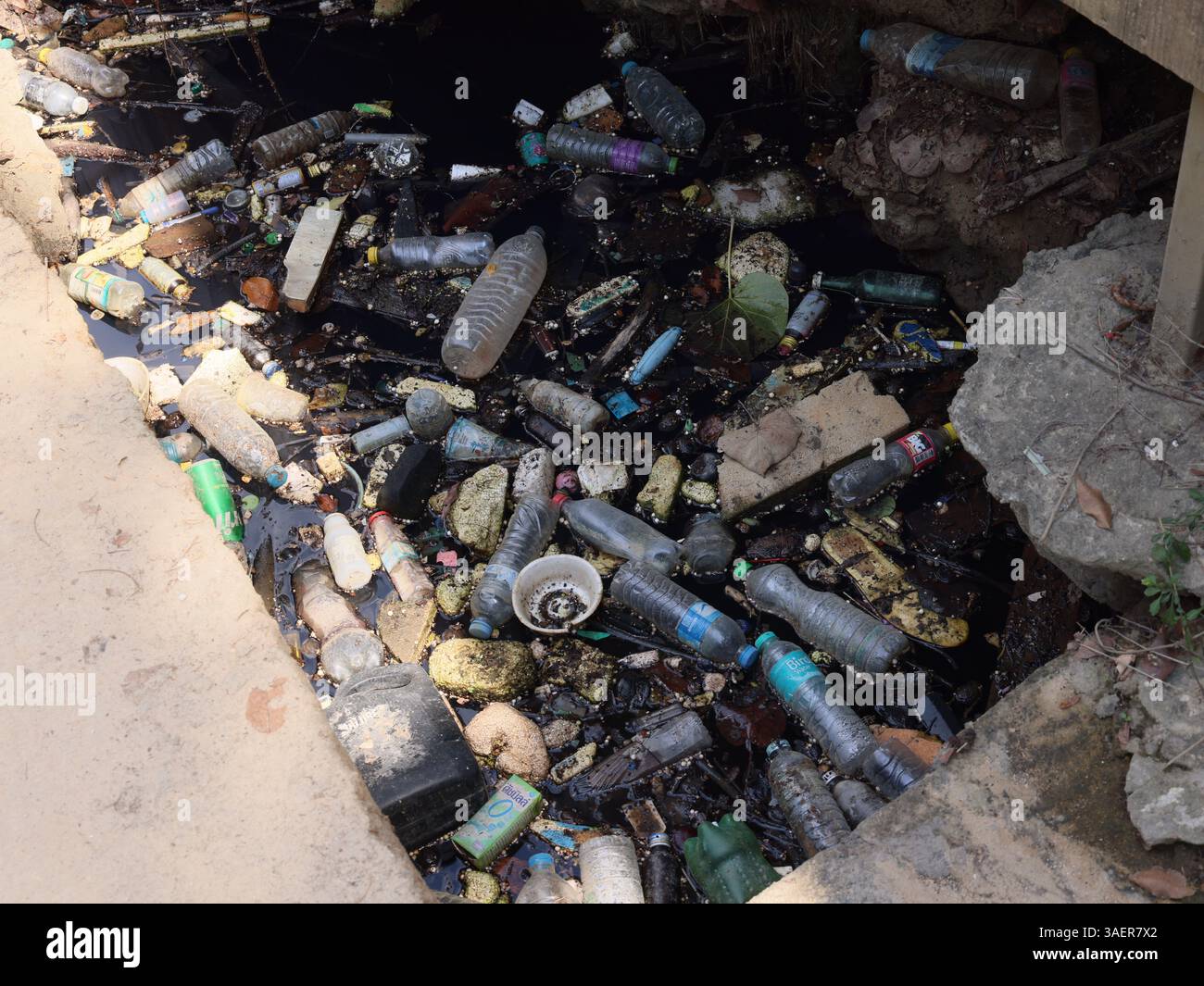 Un corso d'acqua inquinato è pieno di plastica e detriti, ponendo un grave rischio per l'ecosistema Foto Stock