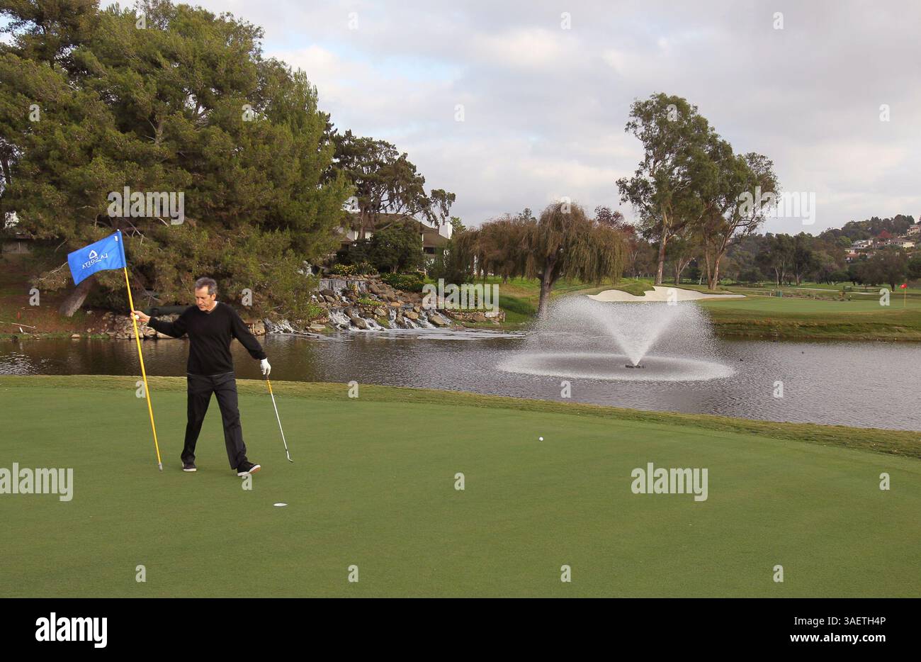 18 novembre 2011 - Carlsbad - 18 novembre 2011, Carlsbad, California, USA_|presso il campo da golf la Costa Resort recentemente rinnovato, Dane Chapin rimuove la bandiera per putt il 15 novembre. il verde è molto più vicino al lago e al 16°. Green dietro di lui dall'altra parte del lago a destra.| foto credito: CHARLIE NEUMAN/San Diego Union-Tribune/ZUMA Press (immagine di credito: © The San Diego Union-Tribune/ZUMAPRESS.com) Foto Stock
