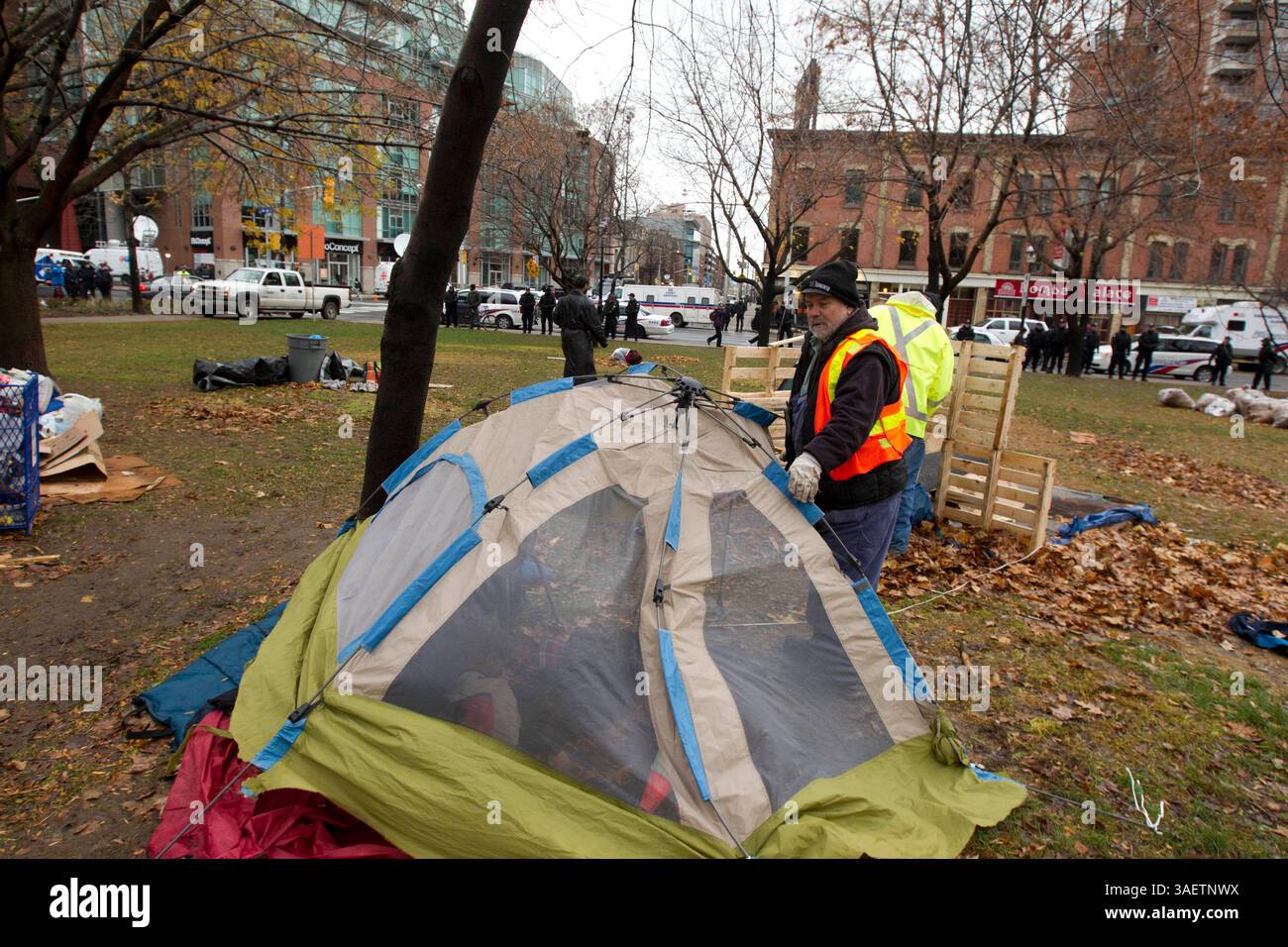 23 novembre 2011 - Toronto, Ontario, Canada - 8:30 - un dipendente della città di Toronto smantellerà una tenda mentre le unità tattiche della polizia si stanno mobilitando intorno al St. James Park. (Immagine di credito: © Chris Drost/ZUMAPRESS.com) Foto Stock