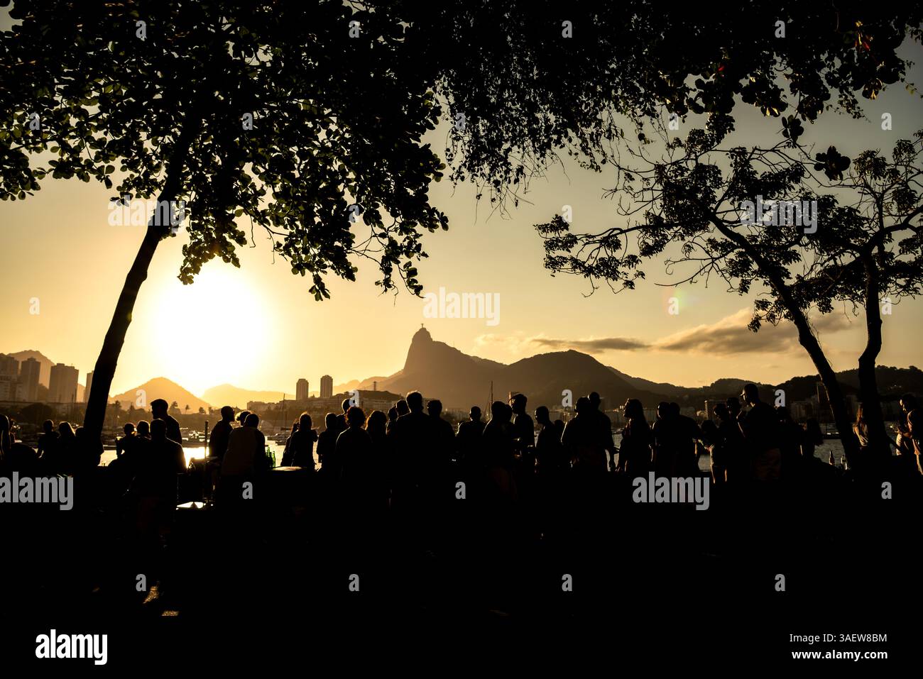 Sagome di persone che guardano il tramonto sul lungomare di Urca con il monte Corcovado - Rio de Janeiro, Brasile Foto Stock