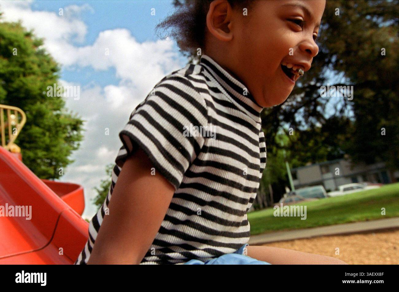 Alisha Hartway di quattro anni ama lo scivolo al parco Los Ninos vicino alla sua casa, all'angolo tra Northview e Northfield Drive a Sacramento. I nuovi dati del censimento mostrano che la percentuale più alta di bambini di 17 anni vive in questo blocco. Sacramento Bee/ Anne Chadwick Williams 4/11/01 /ZUMA Press Foto Stock