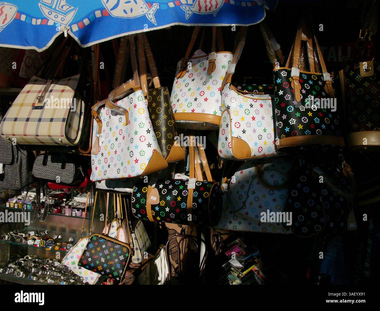 19 dicembre 2004; Venice Beach, CA, USA; borse e accessori di moda Louis Vuitton contraffatti - prodotti realizzati esattamente come i prodotti di marca originali e venduti a ata una frazione del costo di vendita sulla tavola a Venice, California. I turisti acquistano borse firmate false da Gucci, Prada e Louis Vuitton da venditori ambulanti. Il commercio di contraffazioni illegali è un problema comune in tutto il mondo. Foto Stock