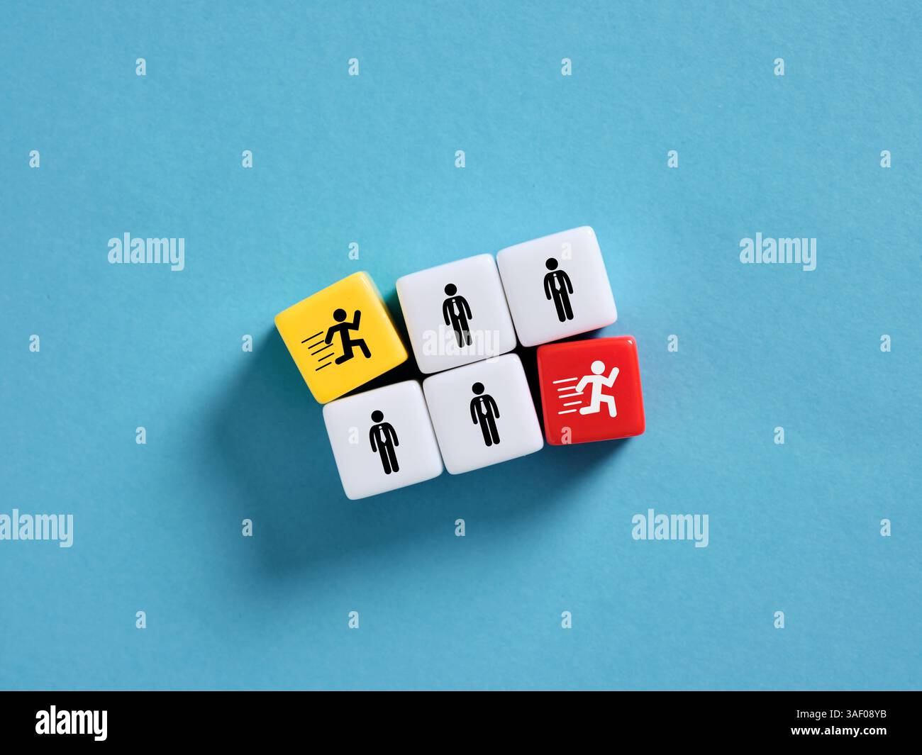 Dadi colorati che mostrano uomini d'affari in corsa e in piedi che rappresentano scelte opposte in ambito commerciale e professionale. Per entrare e uscire dal team o dalla forza lavoro Foto Stock