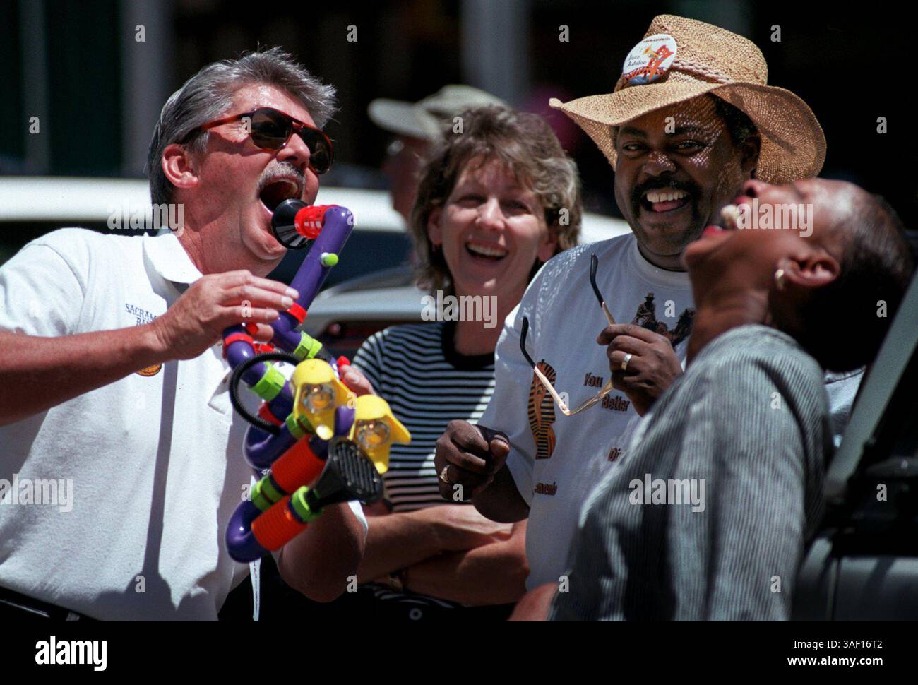 A sinistra, Cary Hobbs, Salt Lake City, Utah, suona il suo ''intestifone'' per gli spettatori alla sfilata di oggi al Jazz Jubilee 2000 a Old Sacramento. Hobbs suona la tuba per la Sacramenton Banjo Band esibendosi al festival di quest'anno. La folla ridendo comprende il centro, Vicki Swain, West Palm Beach, Flag., seconda da destra Les Cochren e moglie (a destra) Rosetta Cochren di Sacramento. Stanno ridendo della moltitudine di suoni che lo strumento di Hobbs può fare. 5/26/00 Thomas Cordy/Sacramento Bee /ZUMA Press Foto Stock