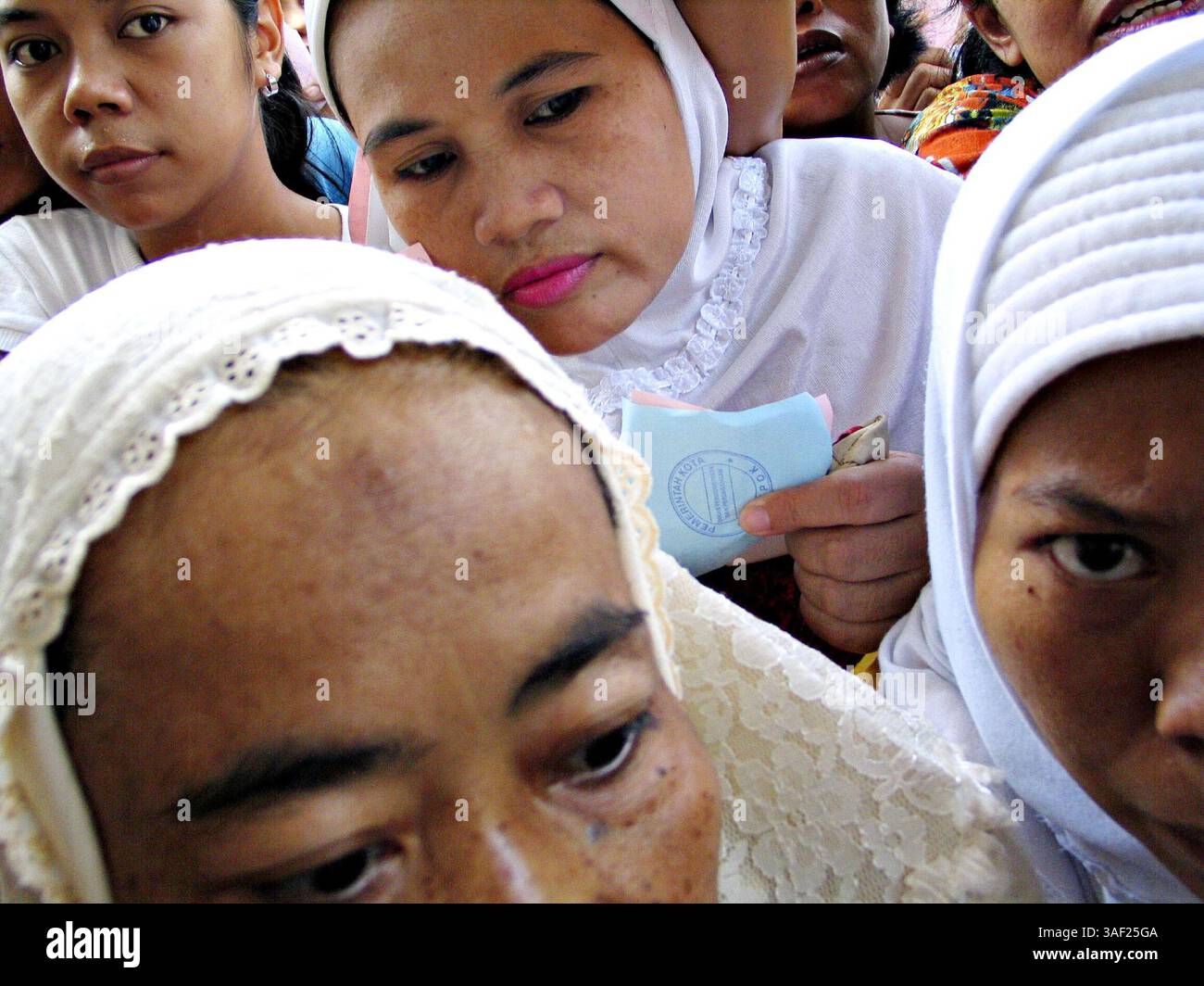 26 ottobre 2005; Depok, Jawa Barat, INDONESIA; molte donne lottano per un pacchetto economico di provviste di base che consiste in spaghetti istantanei, burro, olio da cucina, zucchero, ketchup, salsa di soia, crema di latte, dentifricio e detergente in un bazar tenuto dall'Office of Trade and Industry della contea di Depok. Credito obbligatorio: Foto di Toto Santiko Budi/Jiwafoto/ZUMA Press. (©) Copyright 2005 di Jiwafoto Foto Stock