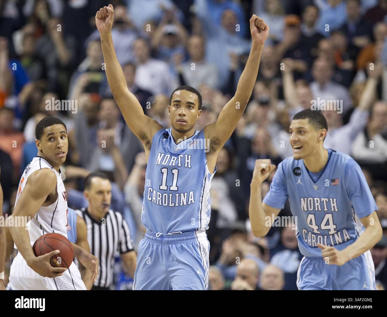 13 marzo 2015 - Greensboro, N. C, USA - Virginiaâ Malcolm Brogdon (15) lascia il campo mentre Carolinaâ Brice Johnson (11) e Justin Jackson (44) celebrano la vittoria del Tar Heelsâ€™ 71-67 sulla Virginia venerdì 13 marzo 2015 nelle semifinali dell'Atlantic Coast Conference Basketball Tournament al Greensboro Coliseum di Greensboro, N.C. (Credit Image: © Robert Willett/News Observer/ZUMAPRESS.com) Foto Stock