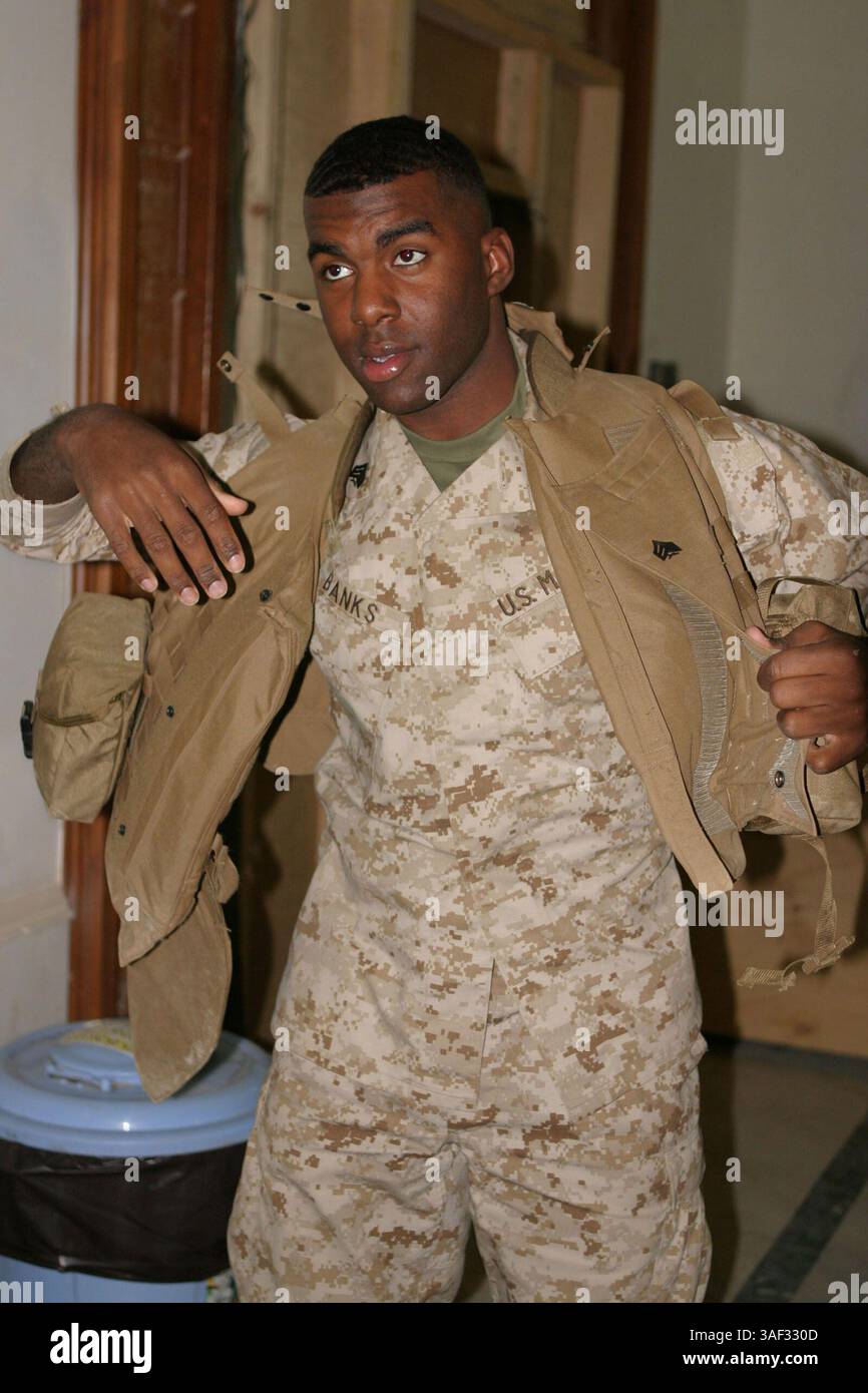 11 marzo 2005; Camp Blue Diamond, Iraq; sergente CRYST BANKS, un impiegato dell'amministrazione del personale di 21 anni, nativo di Washington D.C. e di collegamento della 2d Marine Division morale Welfare and Recreation si mette la sua giacca antiproiettile per andare a parlare con alcuni dei suoi contatti per organizzare l'intrattenimento nei campi per aumentare il morale. Foto Stock