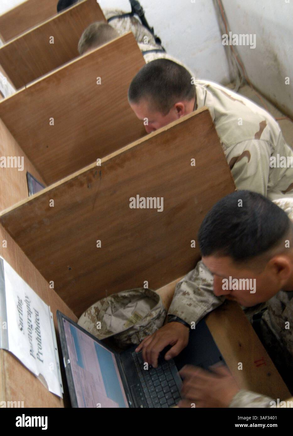 25 dicembre 2004; Camp Ramadi, Iraq; i Marines e i marinai usano i computer all'11 febbraioÕs Internet caf. Il giorno di Natale, i Marines e i marinai della batteria D'artiglieria, 2° Battaglione, 11° Reggimento Marines, 1° Divisione Marines, hanno avuto il giorno libero, per fare quello che volevano. Foto Stock
