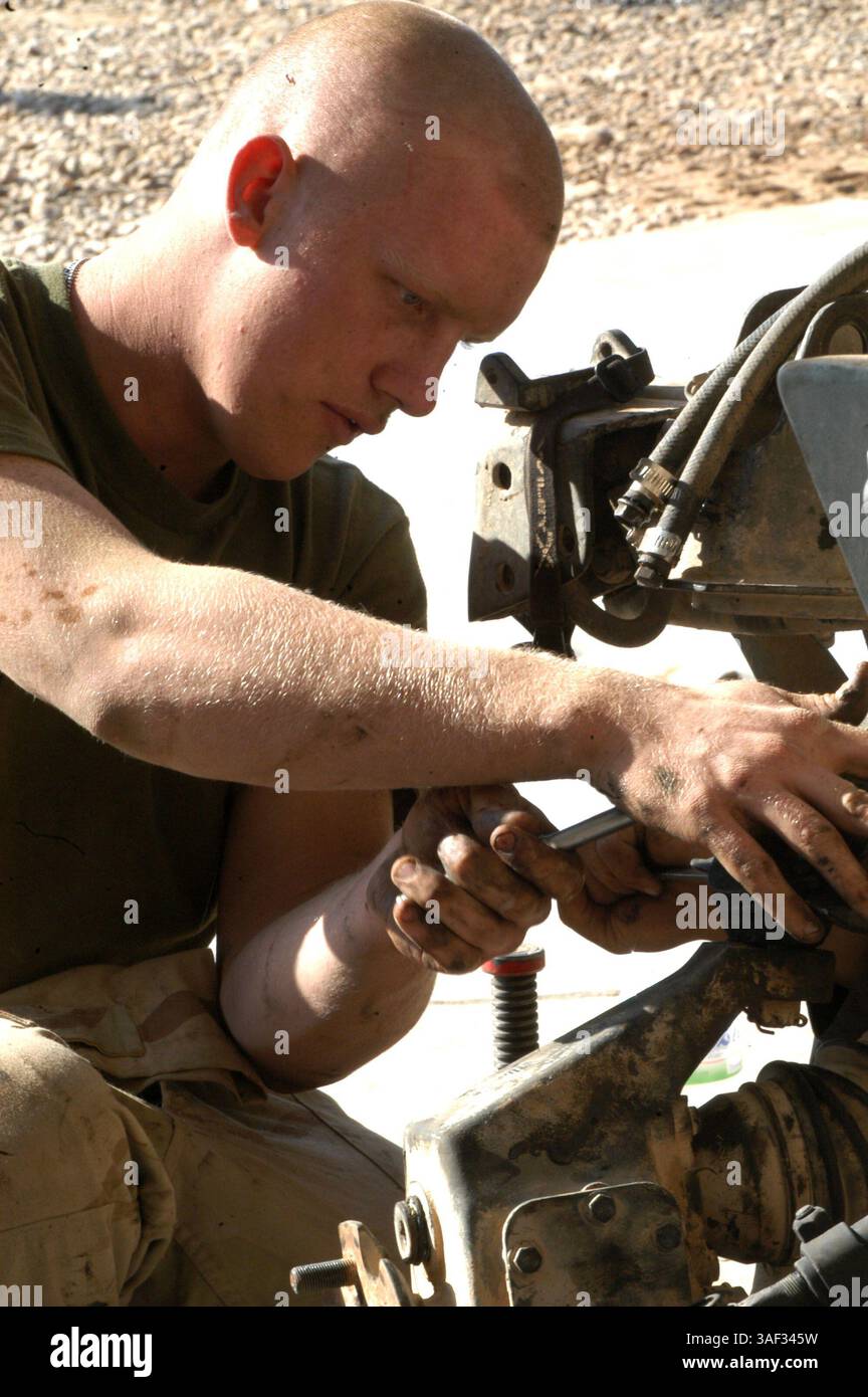 28 dicembre 2004; Camp Ramadi, Iraq; Lance Cpl. MICHAEL GATTON, meccanico, plotone di trasporto a motore, 2nd Battalion, 11th Marine Regiment, 1st Marine Division, lavora alla sospensione di un'humvee. Con un organico di 20 Marine di meccanici, il plotone di trasporto a motore del 2/11 ha la missione di mantenere il comando dei genitori nella lotta e sulla strada. Foto Stock