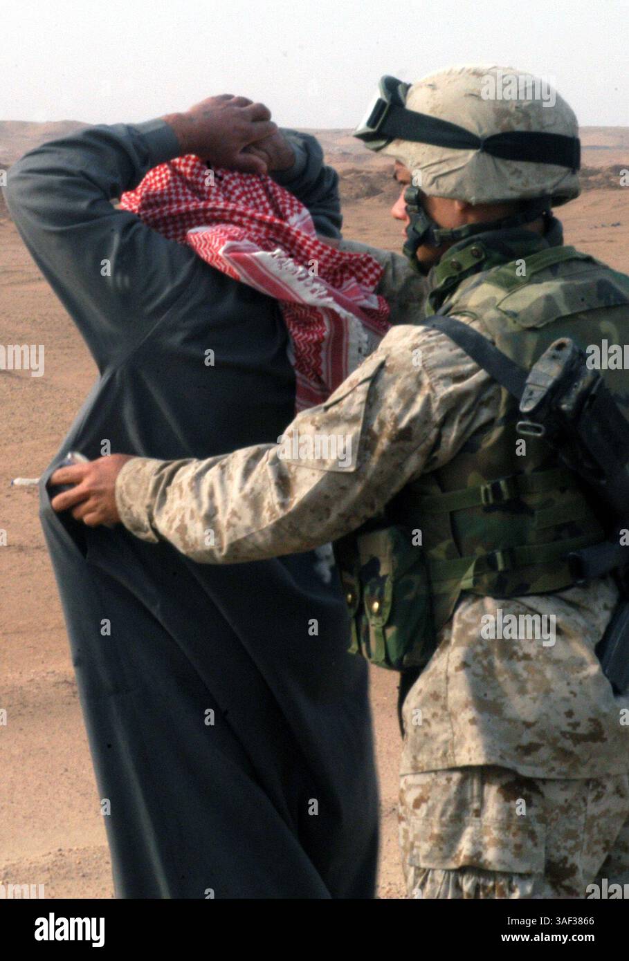 01 gennaio 2005; Camp Ramadi, Iraq; Un Marine con batteria S, 2nd Battalion, 11th Marine Regiment, 1st Marine Division, perquisisce alcuni uomini sospetti mentre si recano a Camp Ramadi. Mentre il 2° Battaglione, 11° Reggimento Marines è un battaglione di artiglieria sui libri, ha una missione di polizia militare provvisoria durante l'operazione Iraqi Freedom II Foto Stock