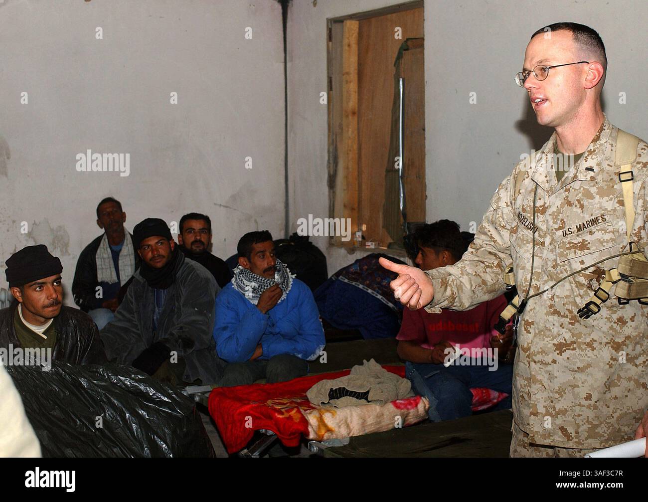 28 gennaio 2005; Mudayisis, Iraq; 1° tenente MICHAEL KOZELISKI, ufficiale delle operazioni, batteria G, 2° battaglione, 11° reggimento dei Marines, fornisce un rapporto a un gruppo di lavoratori elettorali iracheni al loro arrivo a Mudayisis, Iraq, gennaio 28. Kozeliski, un 34enne di Gallup, N.M., ha accolto gli iracheni nella sua base e li ha ringraziati per il loro servizio al loro paese. I lavoratori si sono offerti volontari da tutto l'Iraq per garantire le prime libere elezioni democratiche nella storia del loro paese. Foto Stock