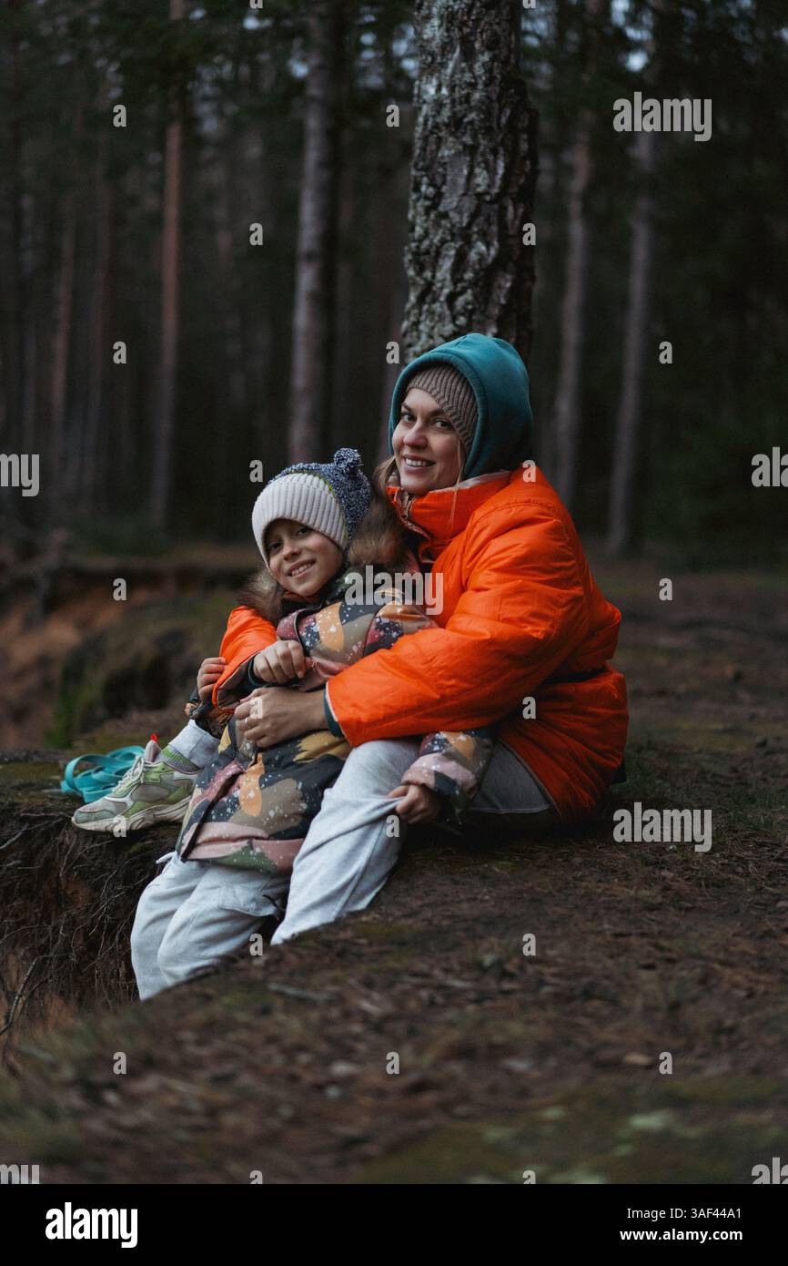 Mamma e figlia in una passeggiata nella foresta invernale Foto Stock