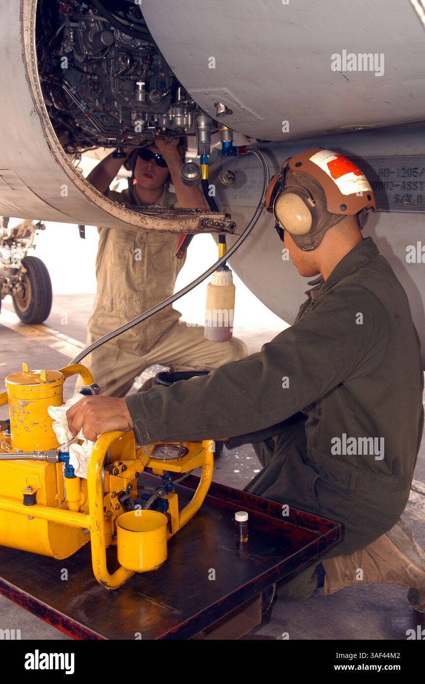 13 aprile 2005; al Asad, Iraq; Sgt. RUBEN MARTINEZ, Powerlines meccanico originario di Dumas, Texas (destra), preleva un campione di olio dal motore di dritta di un EA-6B Prowler restituito di recente. Dopo aver prelevato un campione dal motore portuale, Lance Cpl. STEVE D. WEBER, meccanico di Powerlines e originario di Copley, Ohio, lega la coppa dell'olio. Credito obbligatorio: Foto di Cpl. Rocco DeFilippis/DOD/ZUMA Press. (©) Copyright 2005 di US DOD Photo Foto Stock