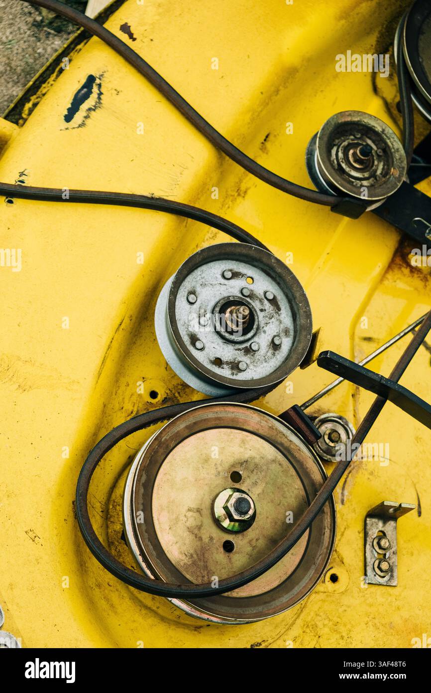 Vista ravvicinata dei componenti del macchinario su un piatto rasaerba giallo Foto Stock