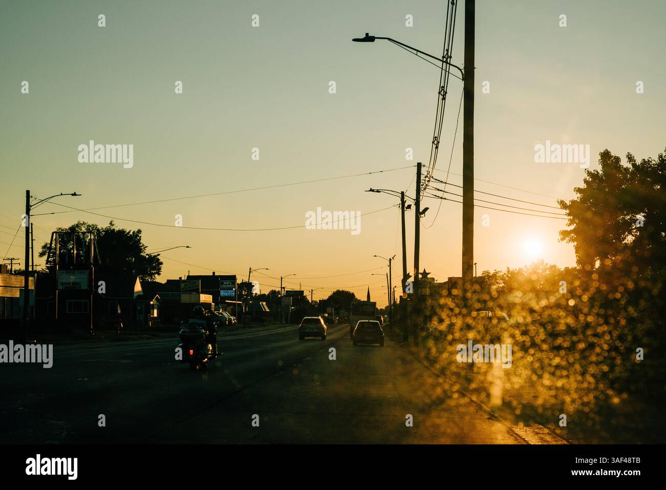 Vista al tramonto di una strada nebulosa con auto durante l'ora d'oro Foto Stock