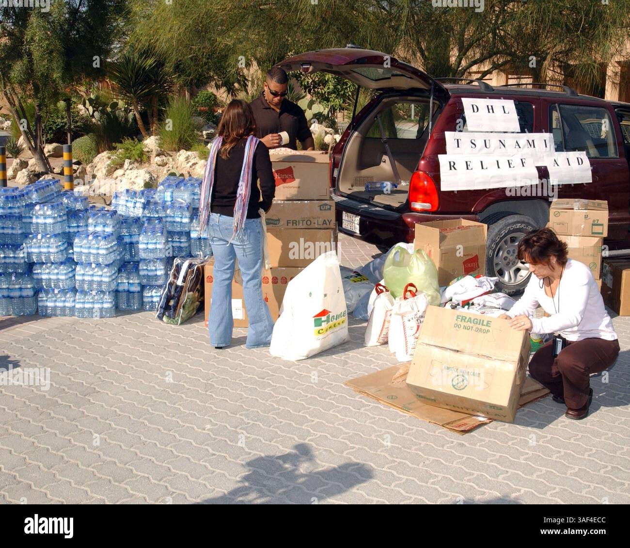 30 dicembre 2004; banda Aceh, Indonesia; volontari della Naval Support Activity (NSA), Bahrain, confezionano cibo e vestiti in scatole che saranno trasportate in Sri Lanka per aiutare le vittime dello tsunami che ha avuto luogo il 26 dicembre 2004 Foto Stock