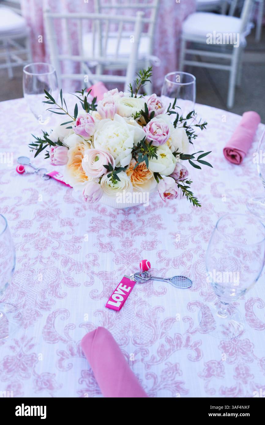 Tavolo a tema tennis con centrotavola floreale e favori D'AMORE rosa Foto Stock