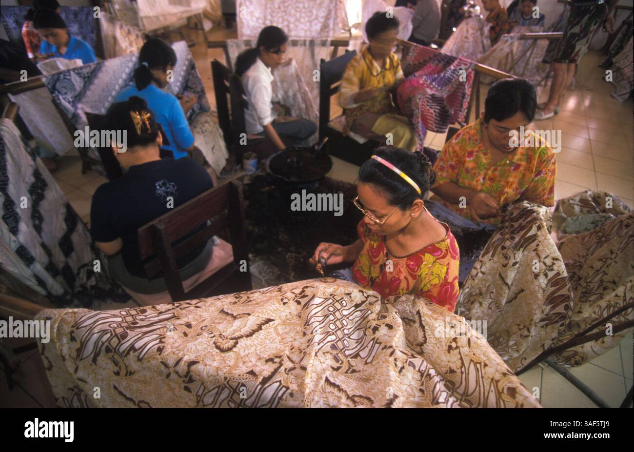 27 marzo 2002; Giacarta, Giava, Indonesia; gli artisti batik fanno batik in gruppi di 5-6 persone al laboratorio di Iwan Tirta a Cibubur, Giacarta sud. Circa 28 artisti Batik lavorano per Iwan Tirta per US $ 3,30 al giorno. Foto Stock
