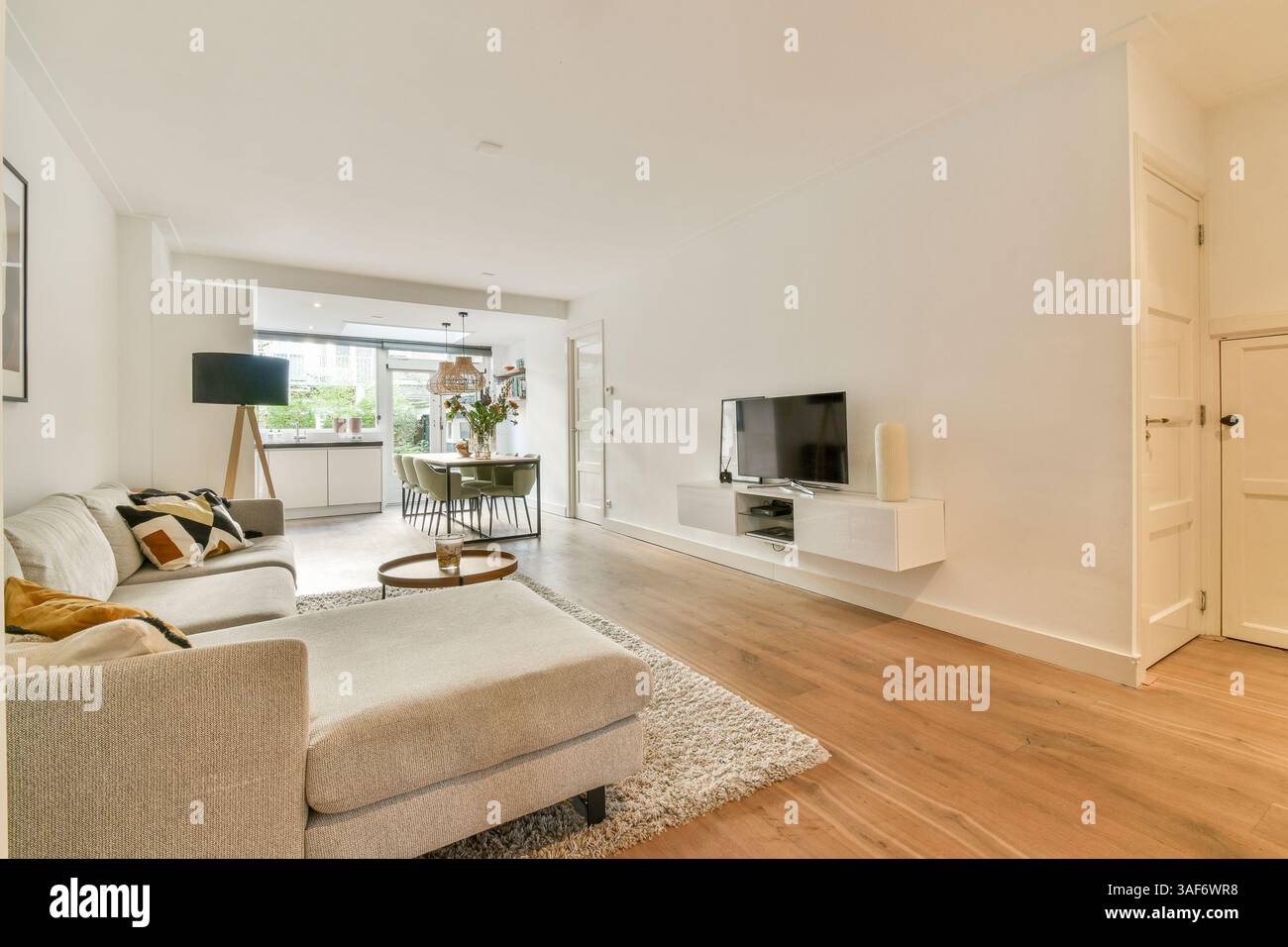 Un soggiorno elegante e contemporaneo con mobili eleganti e una tavolozza calda. Perfetto per rilassarsi e socializzare in un'atmosfera confortevole. Foto Stock