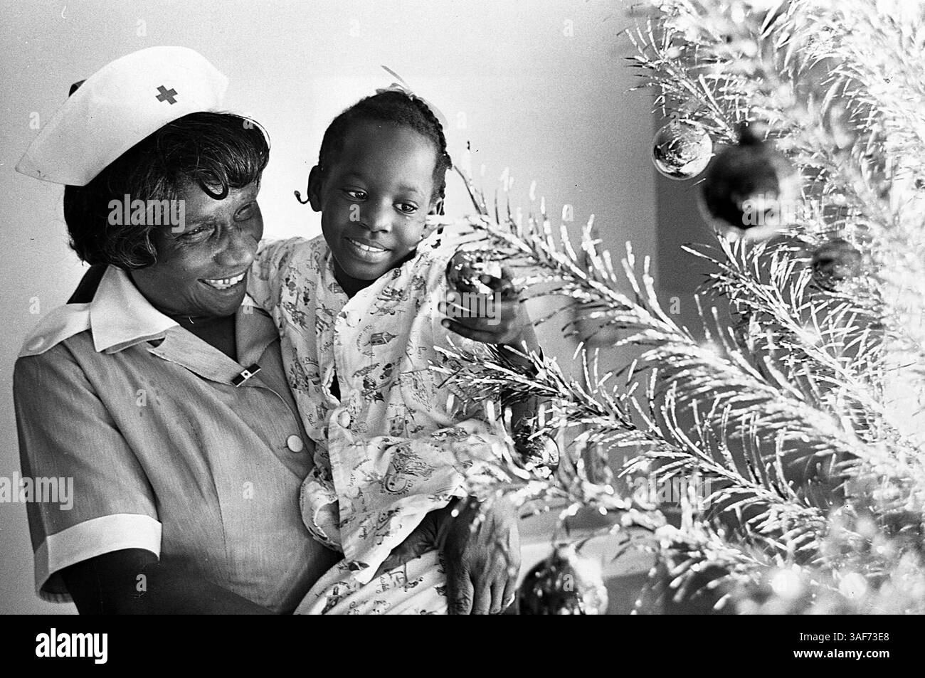 BOZZA DIDASCALIA 39..Sig.ra Mattie L. Moody, presidente della Mercy HospitalÕs Gray Ladies , intrattiene la paziente Jacqueline Henderson con la storia e i simboli del Natale del 1963. Times foto di Bob Hannah. (Immagine di credito: St Petersburg Times/ZUMAPRESS.com) Foto Stock